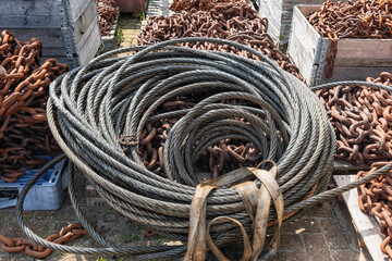 roll of steel cables lie outside on top of rusty steel chains