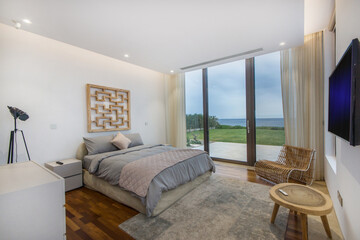 Bedroom With Large Bed and Ocean View.A spacious bedroom positioned to overlook a vast expanse of...