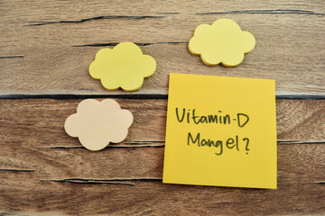 Concept of Vitamin D - Mangel in Language Germany write on sticky notes isolated on Wooden Table.