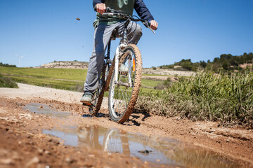 A boy is riding a bike on a muddy road