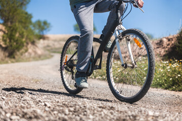 A person is riding a bicycle on a dirt road