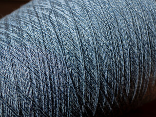 Bobbin of blue melange cotton, woolen or synthetic thread. Cone of yarn for the textile...