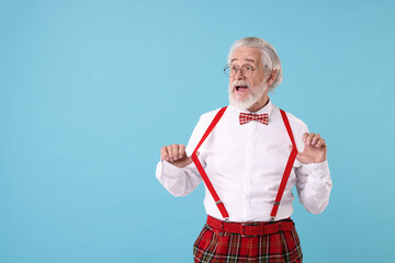 Portrait of stylish grandpa with glasses and bowtie on light blue background, space for text