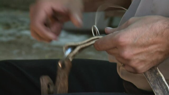 An Argentine Gaucho Repairing Horse Bridles in his Country House. Close Up.