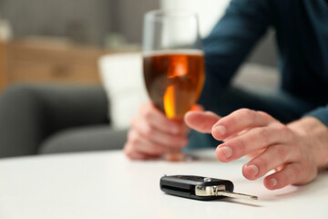Drunk man reaching for car keys indoors, closeup. Space for text