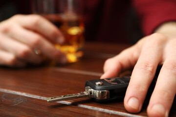 Drunk man reaching for car keys at table, closeup. Don't drink and drive concept