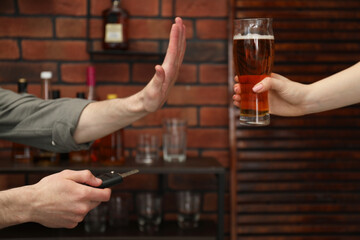 Man with car keys refusing from alcohol while woman suggesting him beer in bar, closeup. Don't drink and drive concept