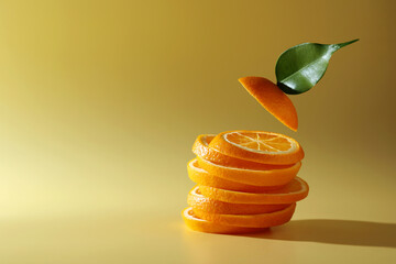 Slices of juicy orange and leaf on beige background. Space for text