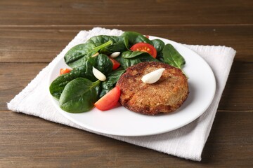 Tasty vegetarian cutlet and vegetables on wooden table
