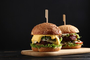 Vegetarian burgers with delicious patties on black wooden table