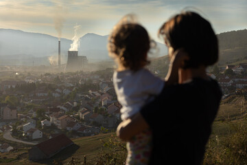 big chimney smoke over the city. Polluted environment. Mother with children watching chimney pollution environment.