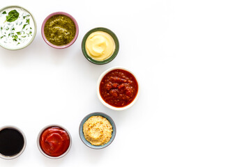 Set of sauces in bowls - pesto salsa mustard and others. Food background