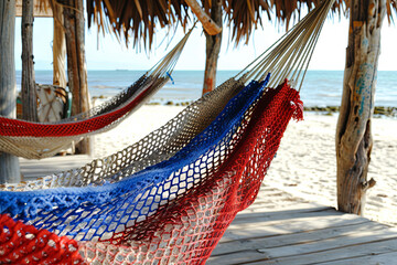 red, white, and blue hammock on a beach