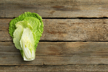 Cut fresh Chinese cabbage on wooden table, top view. Space for text