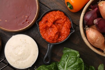 Different marinades and products on wooden table, flat lay