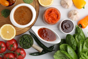 Different marinades and products on white tiled table, flat lay