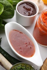 Different marinades in tableware on white table, closeup