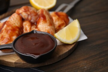 Fresh marinade, raw chicken wings and lemon on table, closeup