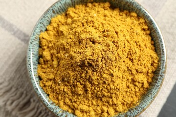 Dry curry powder in bowl on table, top view