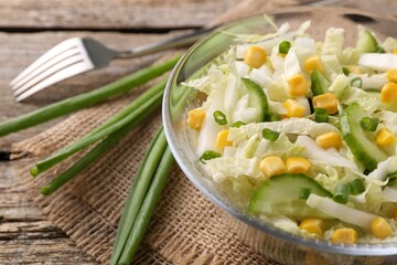 Tasty salad with Chinese cabbage on wooden table, closeup