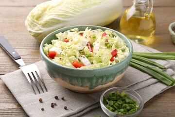 Tasty salad with Chinese cabbage in bowl, peppercorns and green onion on wooden table, closeup