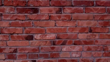 A red brick wall texture with a subtle grain and aged appearance, perfect for adding an authentic...
