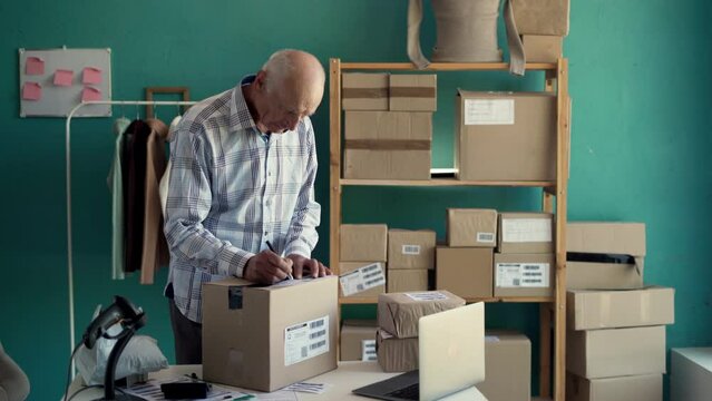 Startup small business SME, online clothes shop owner elderly man checking purchase shopping order to preparing pack product box.