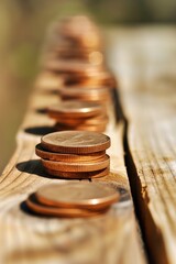 A close-up of a row of neatly stacked US pennies lined up on an old wooden beam in sunlight