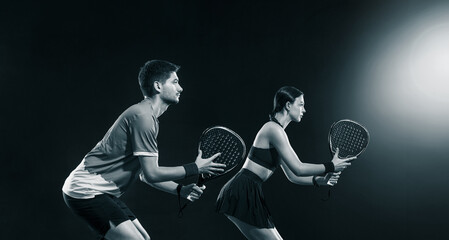 Padel tennis doubles. Two athletes players with racket. Man and woman with paddle racket on court. Sport concept. Download a high quality photo for the design of a sports app