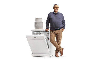Mature man standing next to a dishwasher and a pile od clean plates