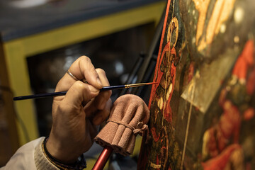 An art conservator's hands delicately restoring an antique painting - precise brushwork, conservation tools - historical preservation - meticulous process, cultural heritage - studio background.