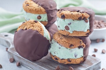 Chocolate covered ice cream sandwiches, mint chocolate chips ice cream , on wooden board, horizontal