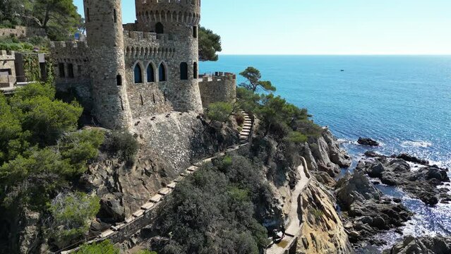Aerial drone view to the fortess in Lloret de Mar, panoramic coastline view with rocks, cliffs, beach, mountains and clean sea, Spain, 4K