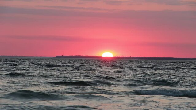 Dramatic evening red sky with the sun rays crossing the clouds. Harmony of seclusion and meditation near the beautiful sea waves. The golden or blue hour of the sunset.	Kinburn, Ukraine.