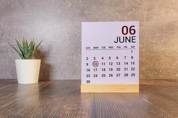 June 10 calendar date text on wooden blocks with blurred nature background.
