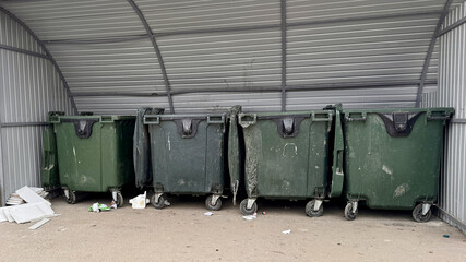 Row of green garbage cans are used for waste containment and garbage collection located in special...