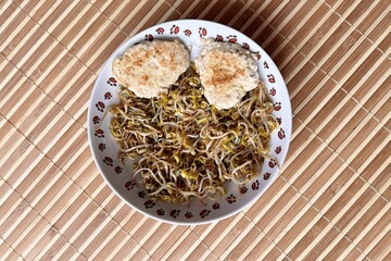 Micro-greenery. Green white sprouted mung beans with two fried cutlet cooking in steam in white...