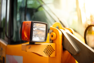 Headlights of a yellow excavator, close-up. 
