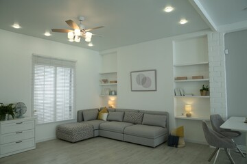 Comfortable furniture, ceiling fan and accessories in stylish living room