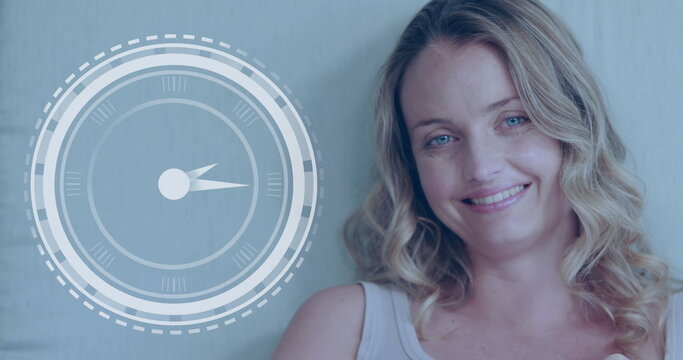 Caucasian fitness class participant smiling, standing near digital clock display