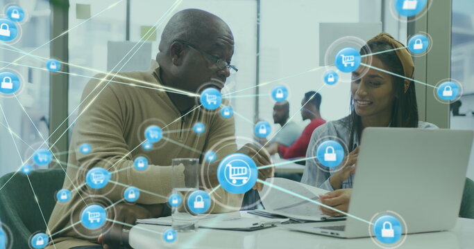 Image of icons connected with lines over diverse coworkers discussing reports on laptop