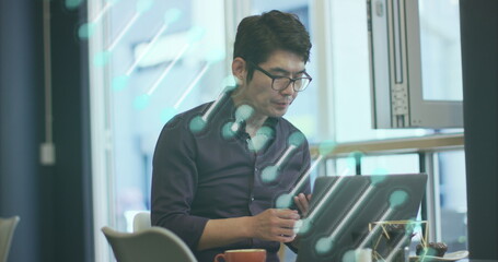 Image of dna strand spinning over asian businessman using smartphone in office