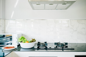 Kitchen space in a luxurious house gas stove by a bright window. Modern design clean furniture...