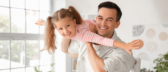 Cute little girl with her dad having fun at home