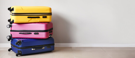Packed suitcases near light wall