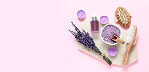 Beautiful spa composition with sea salt, lavender flowers and candles on pink background with space...
