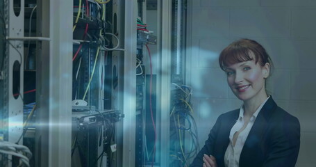 Image of light trails over caucasian female worker in server room