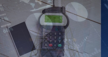 Image of graphs over hand of caucasian man holding payment terminal