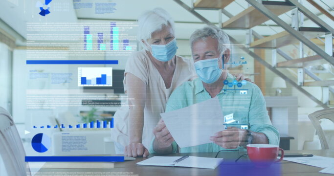 Image of statistical data processing over senior couple wearing face masks reading a document