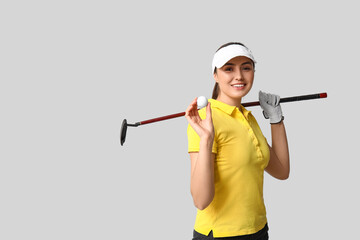 Beautiful female golfer on grey background